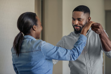 Romantic young African American couple dancing together at home