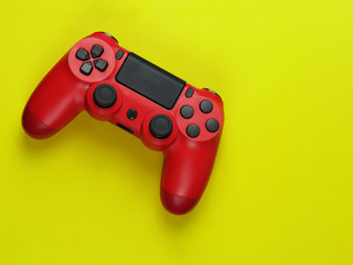 Red gamepad video game controller on colourful yellow background