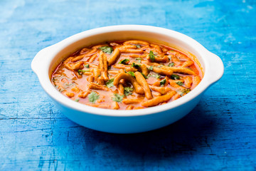 Dhaba style Sev bhaji/sabzi/curry made in tomato curry with gathiya shev, served in a bowl or karahi, selective focus