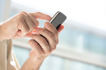 Hands of a mature man using a mobile phone