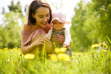 Mother and daughter on a meadow with dandelions