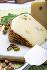 Italian provolone or provola cheese made in Sicily with tasty green Bronte pistachio nuts served on...