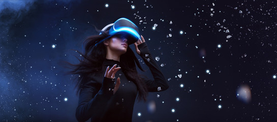 Beautiful woman with flowing hair in futuristic dress over dark background. Girl in glasses of virtual reality. Augmented reality, game, future technology concept. VR. - obrazy, fototapety, plakaty