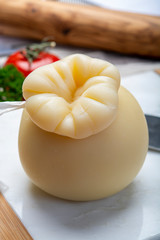 Italian provolone or provola caciocavallo hard cheese in teardrop form served on white marble plate close up