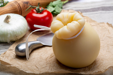 Italian provolone or provola caciocavallo hard cheese in teardrop form served on old paper close up