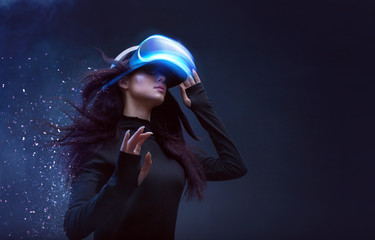 Beautiful woman with flowing hair in futuristic dress over dark background. Girl in glasses of...