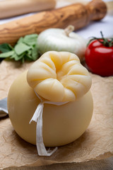 Italian provolone or provola caciocavallo hard cheese in teardrop form served on old paper close up