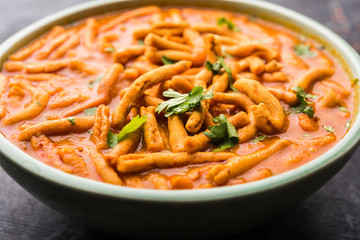 Dhaba style Sev bhaji/sabzi/curry made in tomato curry with gathiya shev, served in a bowl or karahi, selective focus