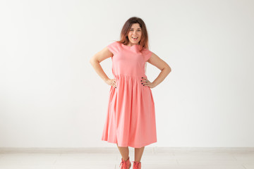 people, fashion and design concept - young woman posing in rose dress on white background with copy space