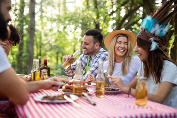 Happy friends camping and having a barbecue in nature