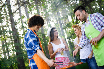 Group of friends having a barbecue and grill party in nature