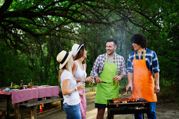 Group of happy friends having a barbecue party in nature