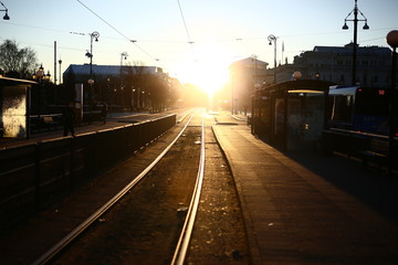 Fototapeta na wymiar Early winter morning on a tram stop with strong sunlight on the Avenue, Gothenburg, Sweden