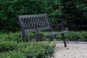 Metal bench in palace park on green background