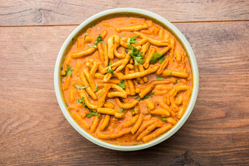 Dhaba style Sev bhaji/sabzi/curry made in tomato curry with gathiya shev, served in a bowl or karahi, selective focus