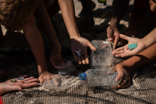 Volunteers finding waste with a net at beach on a sunny day