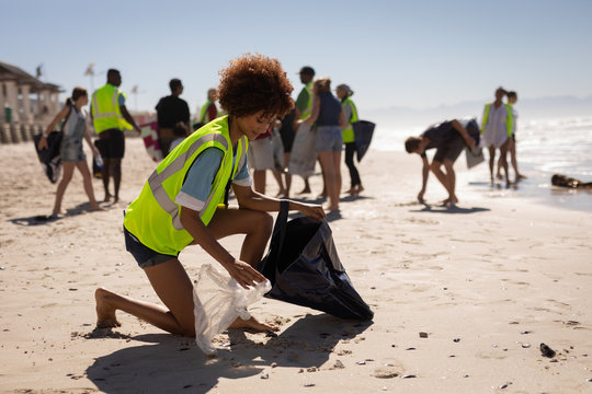 Female volunteer cleaning beach on a sunny day