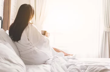 asian woman relaxing in the hotel room, drinking morning coffee, copy space © Siriporn