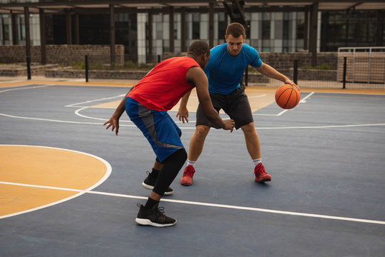Players playing basketball at basketball court