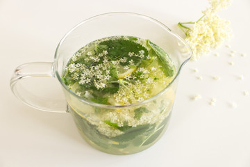 Homemade elderflower lemonade with lemon and elderflower on a wooden table. Summer cold and ,refreshing drink.