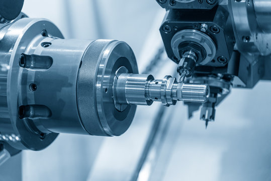 The turn-mill machine cutting groove at the metal shaft. The hi-technology parts manufacturing process by CNC lathe machine .