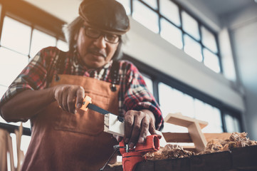 Carpenter working on woodworking machines in carpentry shop
