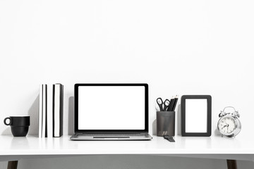 Digital technology Laptop with blank screen and book,picture frame,cup coffee, clock on white table of wood ,Home interior or office background
