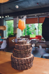 ice cubes falling into a splashing orange cocktail.