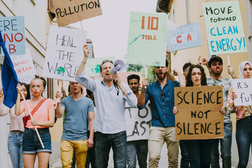 Public demonstration on the street against global warming and pollution. Group of multiethnic...