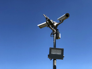 security camera with solar panel across blue sky