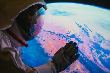 Astronaut looking planet earth from the window of his capsule. Concept about science and space...