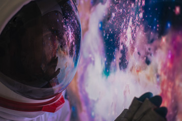 Astronaut looking deep space, galaxy and planets from the window of his capsule. Concept about...