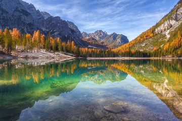 Gorgeous and chic colourful autumn view of Lago di Braies in Dolomites mountains forest.  Amazing autumn forest is reflected in the emerald surface of the water. South Tyrol. Dolomite, Italy, Europe. 