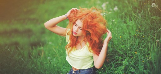 Happy young redhead woman sitting outdoors with closed eyes in summer park Peaceful girl enjoy rest and relax in tranquility in spring bloom. Mindset inner peace concept. Positive emotion, mind zen.