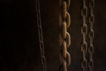 Close up rusty on the group of old chains in low light with copy space. Selective focus and vintage processed. Background for a business target or network system concept.
