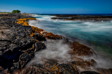 A lava cut in the ocean on a clear day at Wawaloli Beach Park on the island of Hawaii, USA