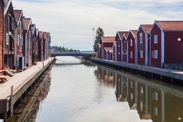 Fototapeta premium Old red wooden port warehouses next to the water in Hudiskvall historic center, Sweden