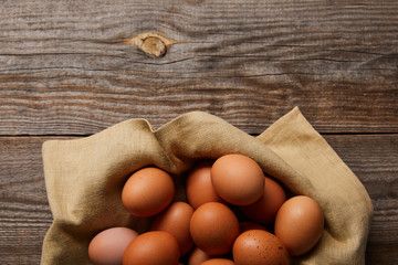 top view of chicken eggs at cloth on wooden table