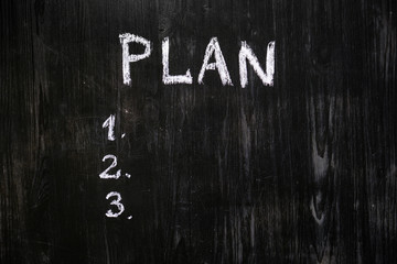 Plan list handwritten with chalk on blackboard. Black wood background and a list of scheduled tasks...