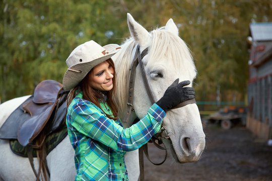 cute smiling cowgirl with a white horse.