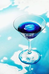 Fresh purple butterfly pea or blue pea flower and juice in glass on  table blue and white background with green blur light space background design, photo montage or advertising