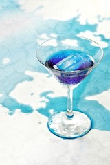 Fresh purple butterfly pea or blue pea flower and juice in glass on  table blue and white background with green blur light space background design, photo montage or advertising