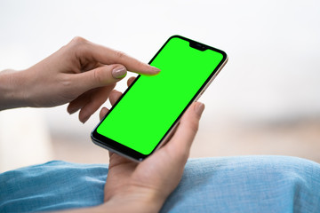 close-up view of young woman using her mobile phone with blank screen