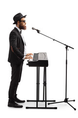 Male musician playing a digital piano and singing on a microphone