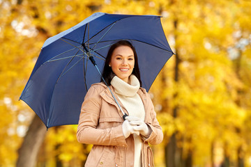 season, weather and people concept - beautiful happy young woman with umbrella in autumn park