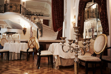 Interior of luxury restaurant in vintage aristocratic style with piano on the stage