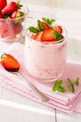 Strawberry smoothie in glass on wooden table