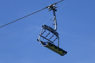 One chair of chairlift in the blue sky in amusement park