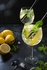 Two shot of mojito cocktail in glass with garnish on black table. Close up.