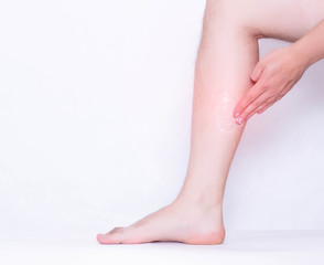 A man rubs a medical ointment in the damaged leg and calf muscle, a healing cream for stretching the ligaments and against inflammation, pain relief, copy space